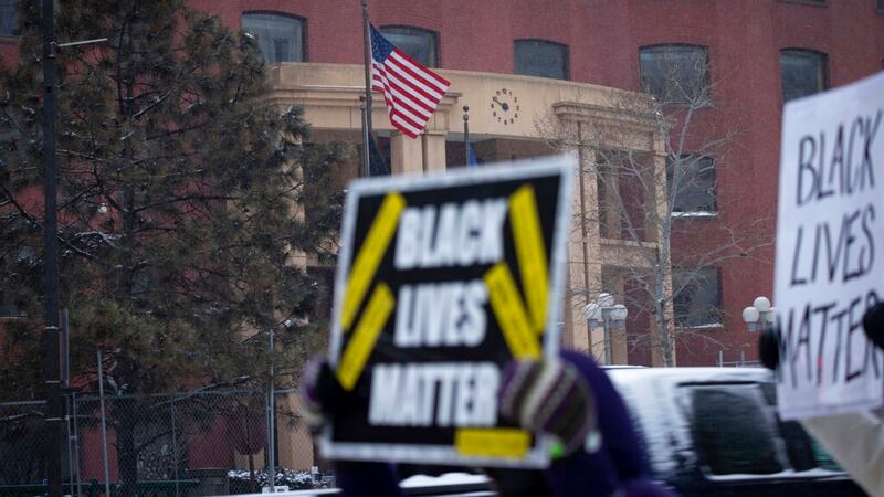 A woman holds a Black Lives Matter sign outside of the Warren E. Burger Federal Building after...