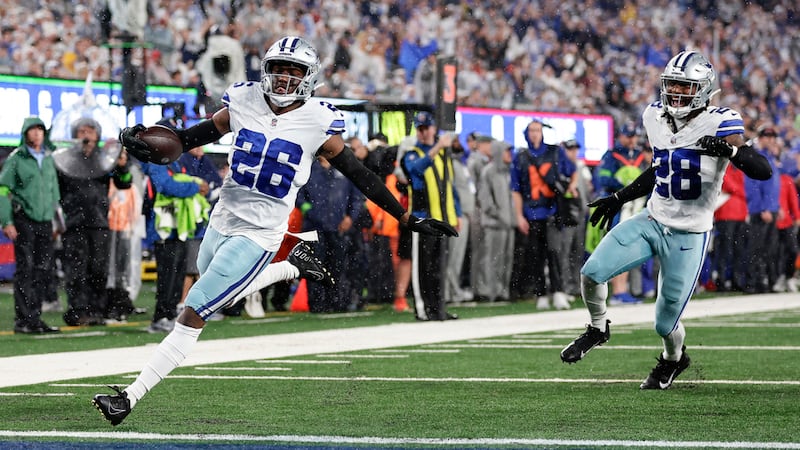 Dallas Cowboys' DaRon Bland, left, reacts as he scores after intercepting the pass intended...