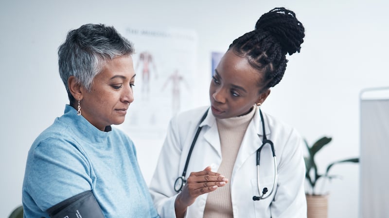 Black woman, doctor and senior patient with blood pressure reading for wellness, advice and...