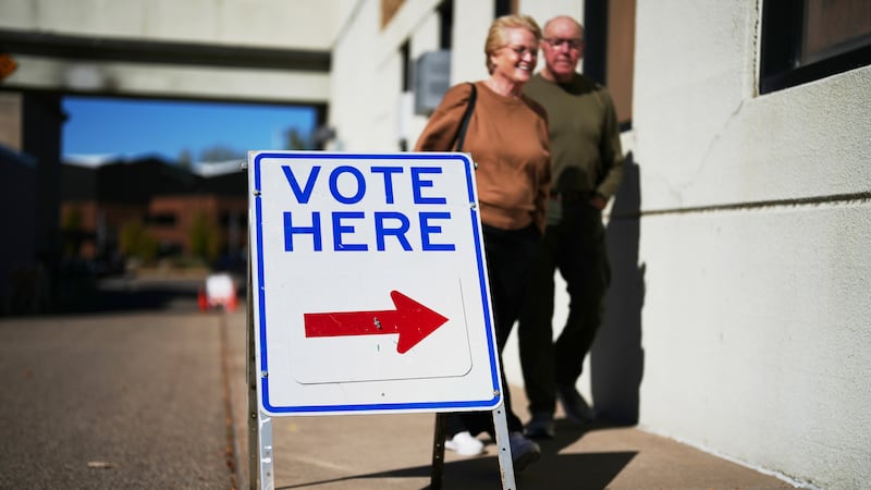 A sign invites voters to cast their ballots on Wisconsin's first day of early voting, Tuesday,...